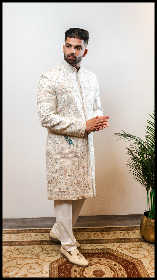 Off-white Mor Nazrana groom sherwani with hand embroidery, featuring pearl and stone detailing and a regal peacock motif.
