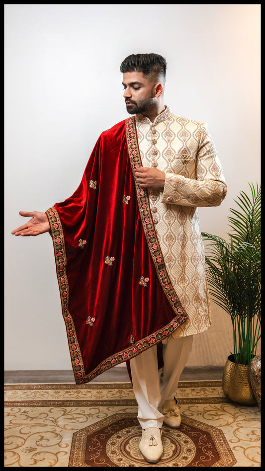 Cream beige Nazm Sherwani featuring intricate embroidery inspired by palace carvings, with hand-embroidered maroon and pink accents on the collar and buttons.