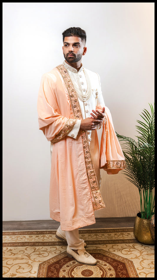 Powder white Sherwani Saga groom sherwani featuring subtle embossed motifs and hand-embroidered collar and buttons, paired with sleek cotton lycra trousers.